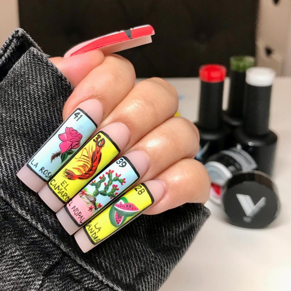 Loteria card nail art featuring a rose, shrimp, cactus, and watermelon designs.