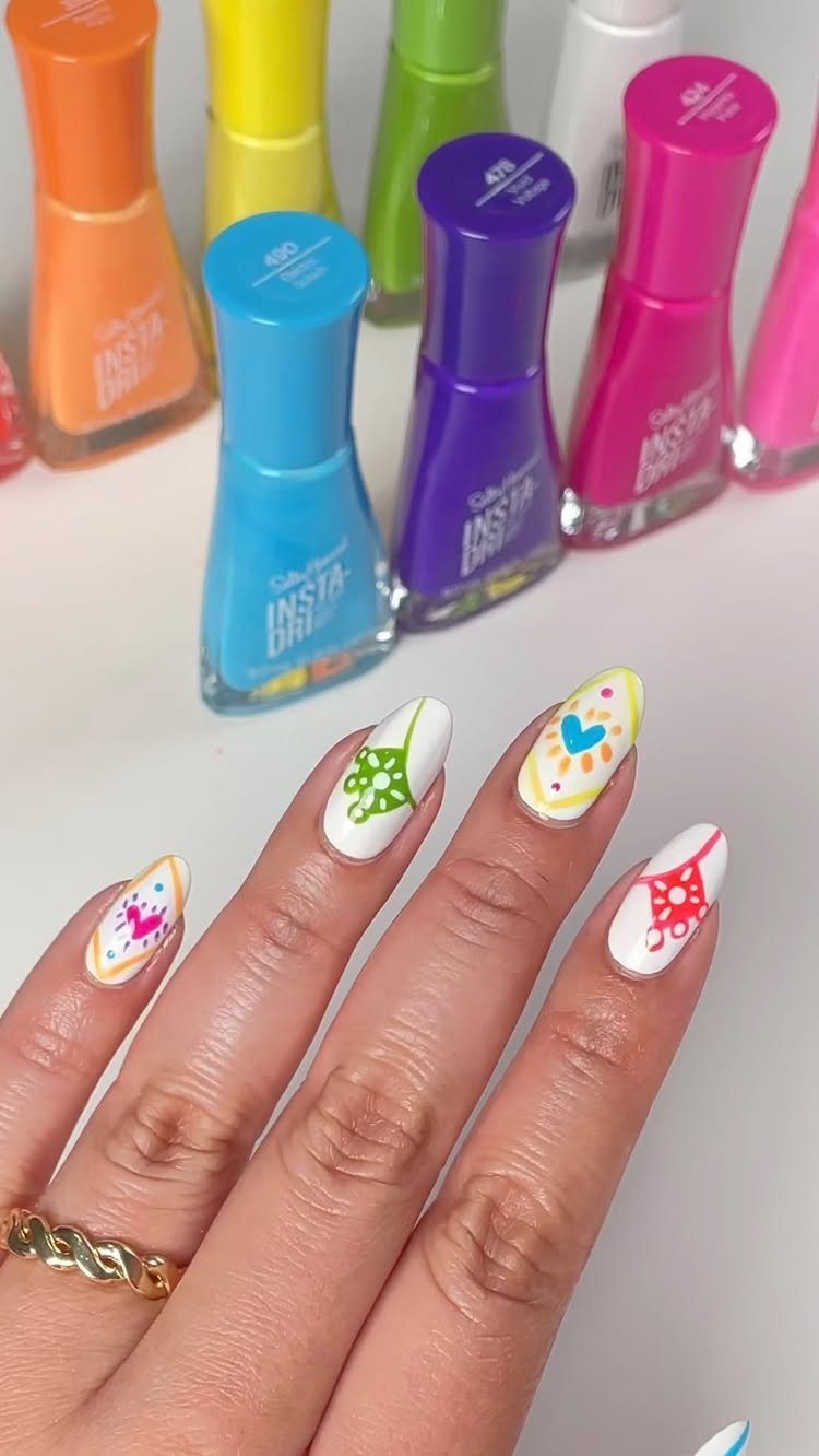 Almond-shaped nails with white base and colorful papel picado inspired patterns.
