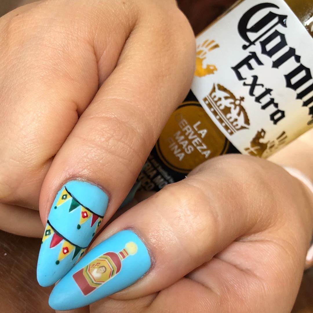 Light blue matte nails with festive bunting and tequila bottle nail art.