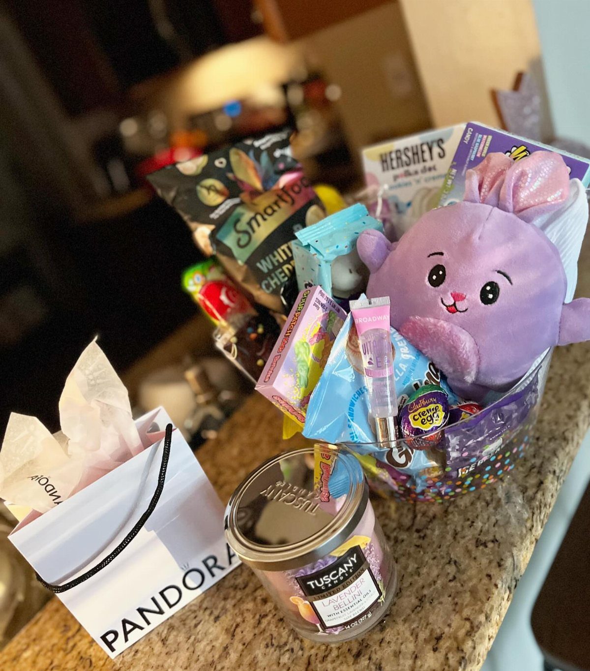 Easter basket containing a purple plush bunny, Smartfood popcorn, and various candies.