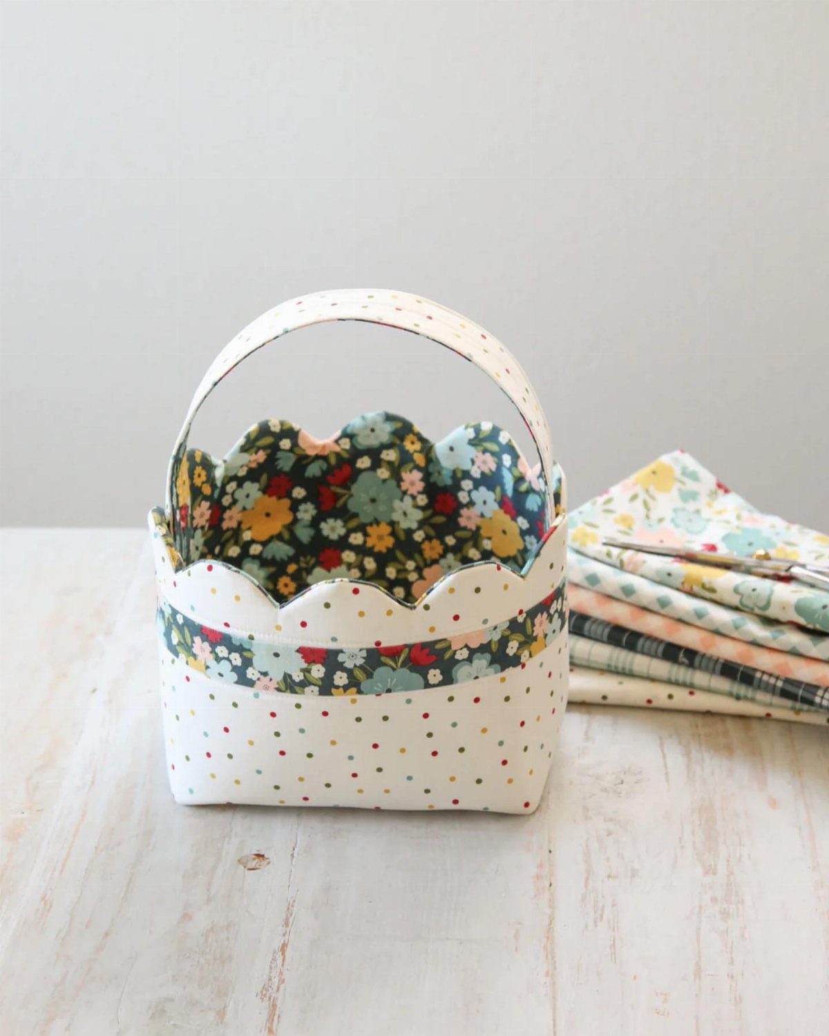 Fabric Easter basket with polka dots and floral lining on white wooden table