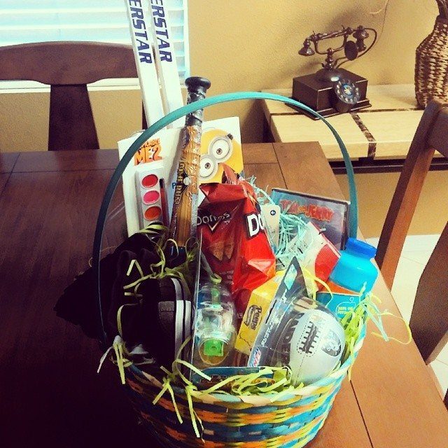 Colorful woven basket filled with sports toys and snacks on a wooden table.