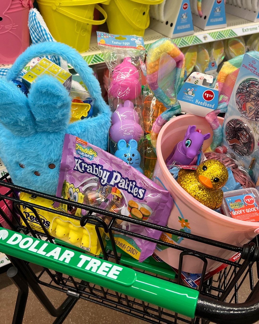 Easter basket items in a Dollar Tree shopping cart including plush bunny and candy