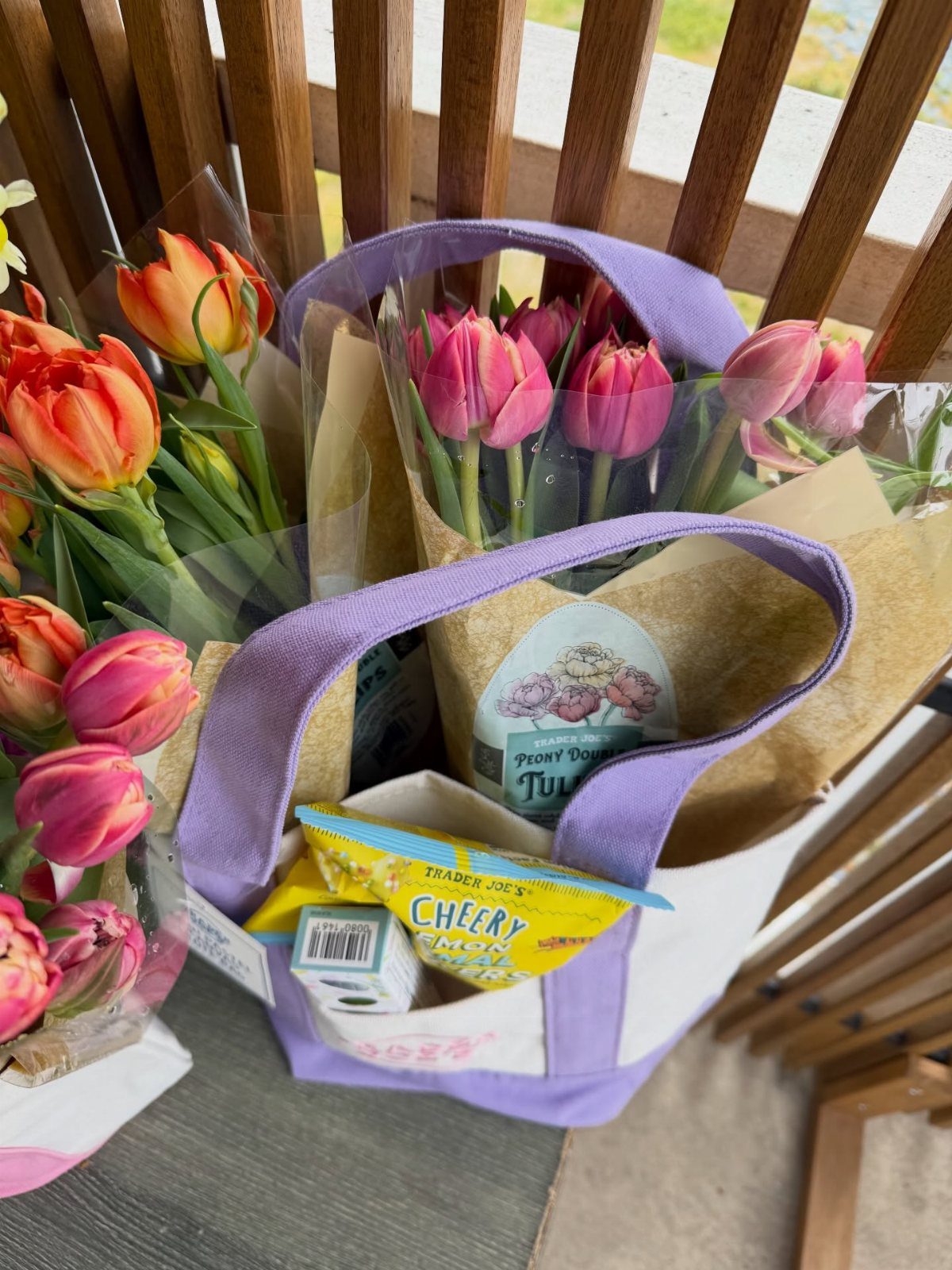 Purple tote bag filled with pink tulips and snacks as adult easter fillers.