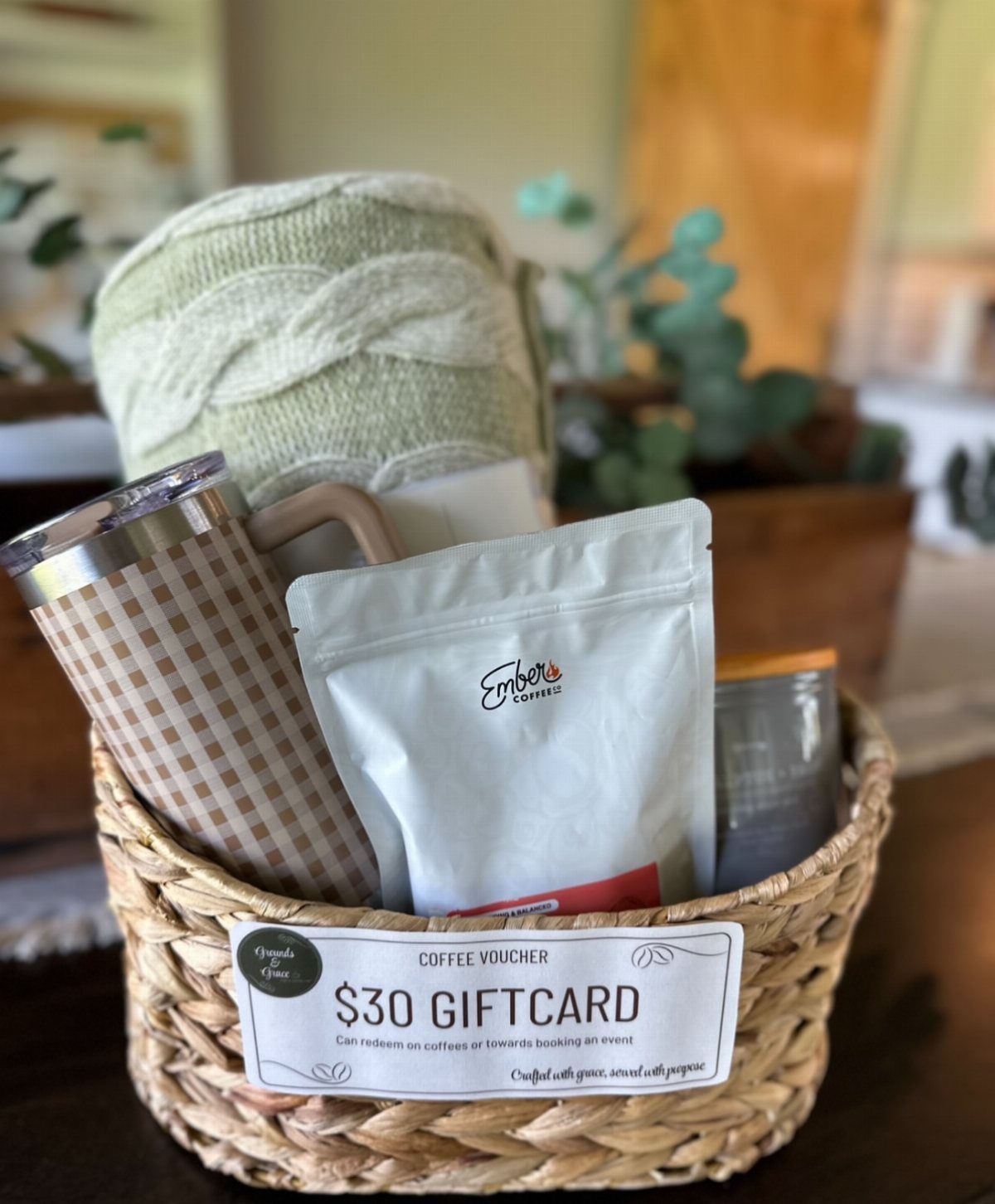 Woven basket with gourmet coffee bag, checkered travel mug, and a coffee gift card.