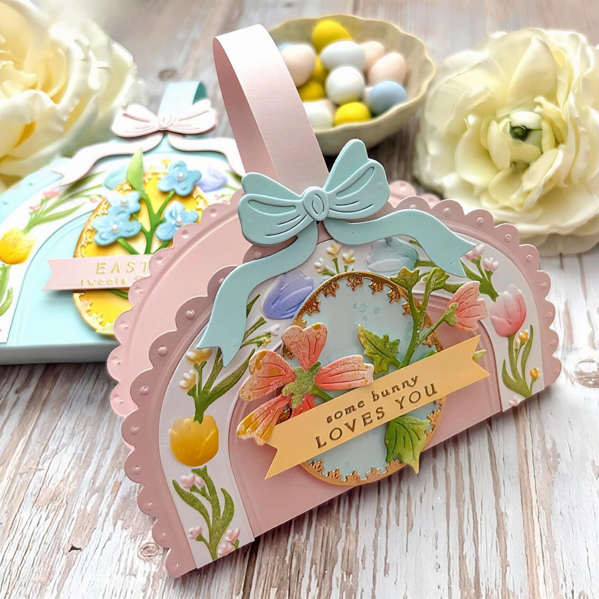 Pink floral Easter gift tag with a blue bow and pastel candy eggs.
