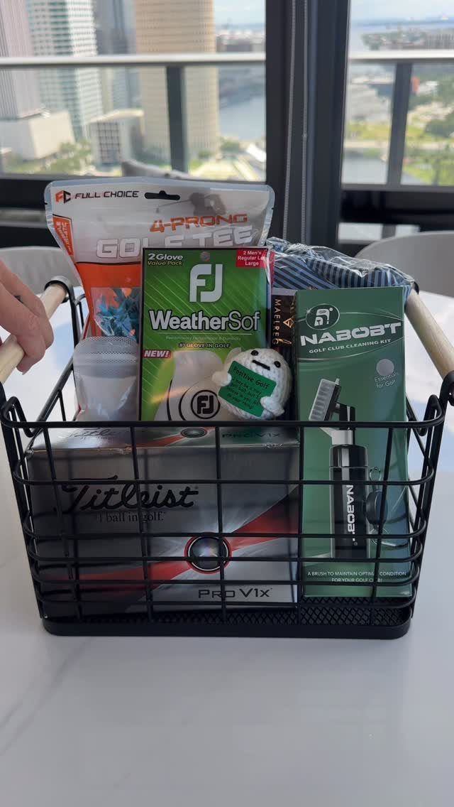 Black wire gift basket filled with golf accessories and an electric toothbrush.