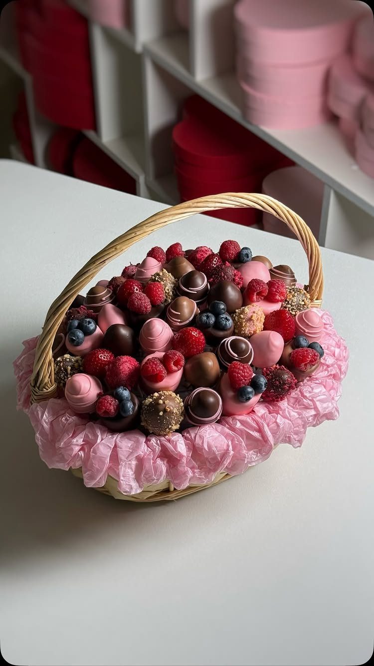 Wicker basket filled with gourmet chocolates, fresh berries, and pink marshmallows.