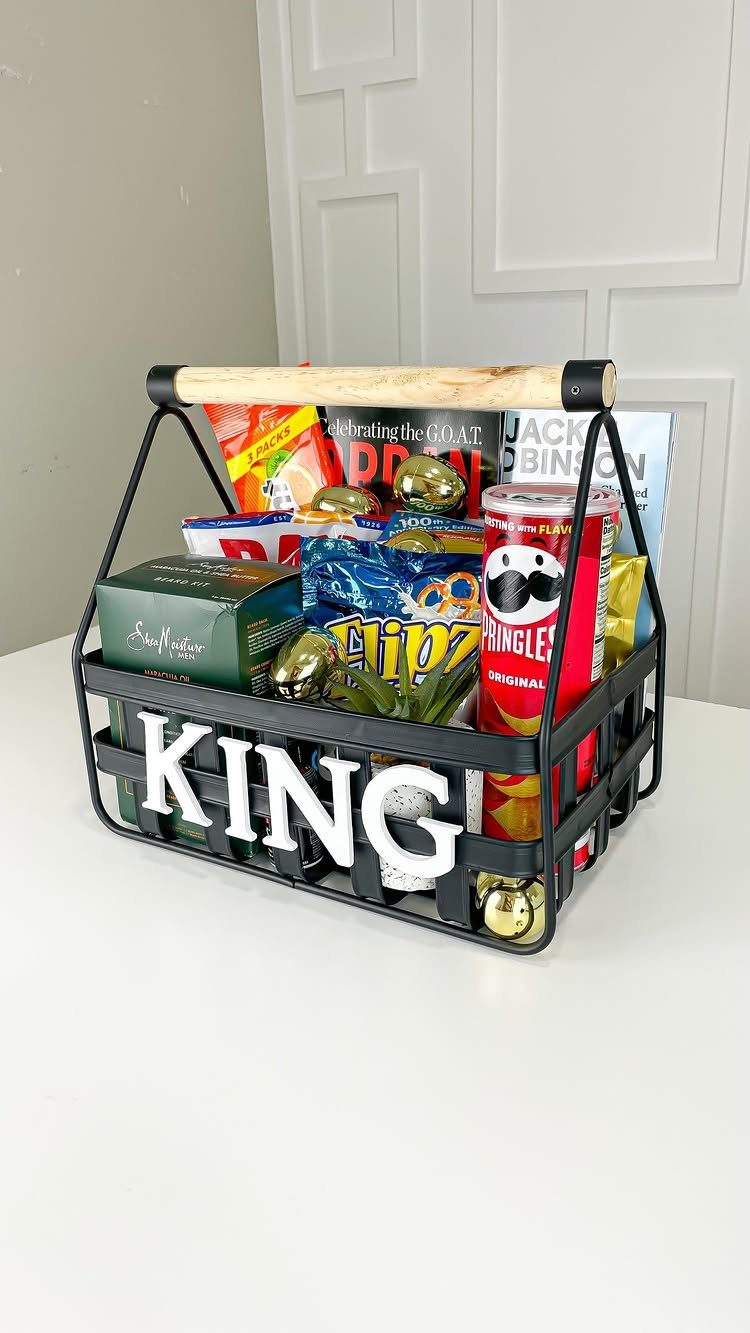 Black wire gift basket labeled KING filled with snacks and gold Easter eggs.