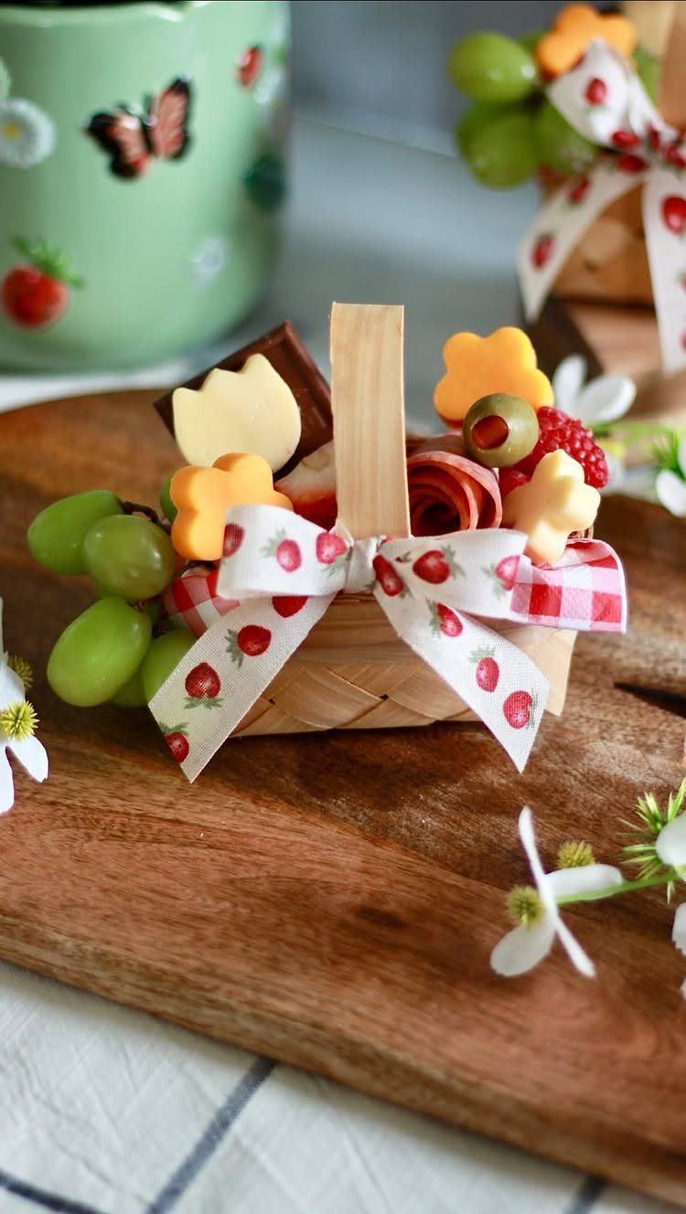 Small woven Easter basket filled with charcuterie and sweets on a wooden board.