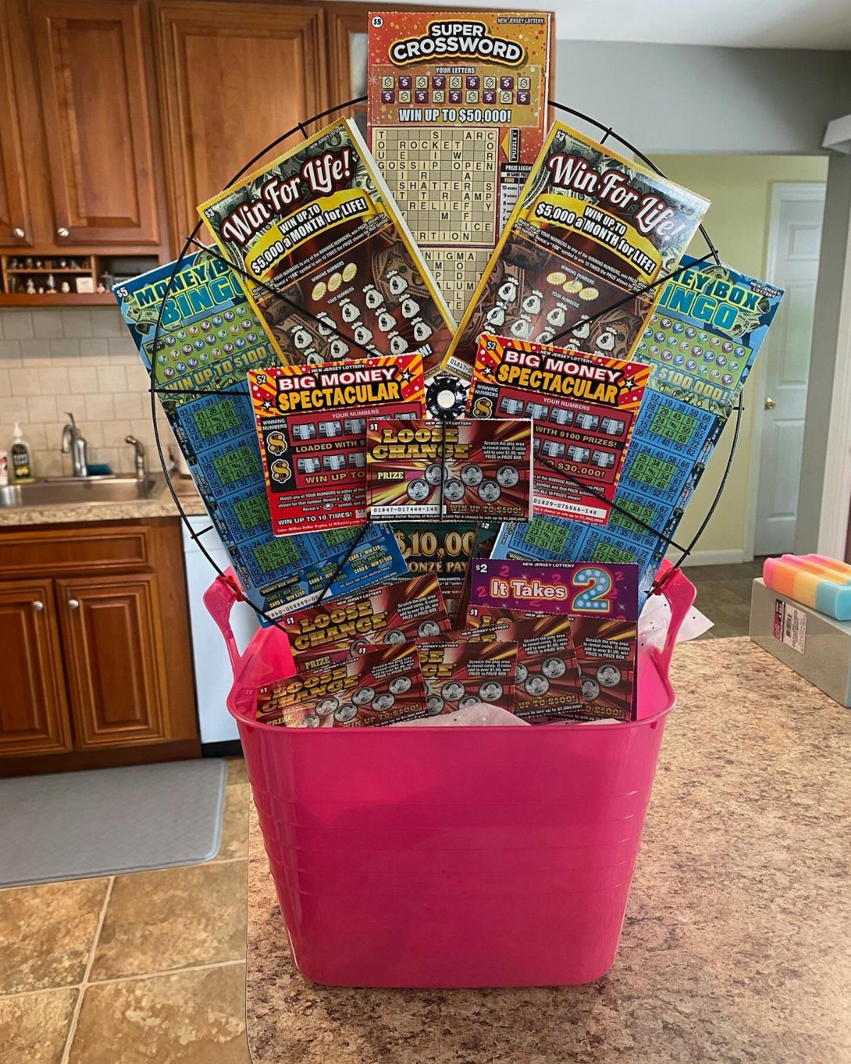 Pink Easter basket filled with a fan of colorful lottery scratch-off tickets.