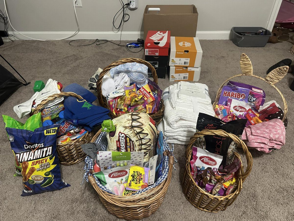 Wicker baskets filled with snacks, candy, and clothing on a grey carpet.