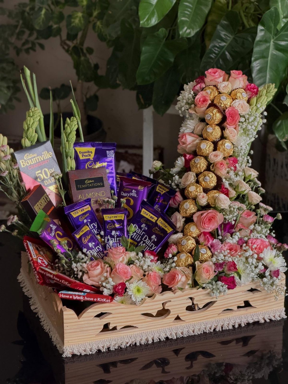 Wooden gift tray with Cadbury chocolates, pink roses, and Ferrero Rocher candies.