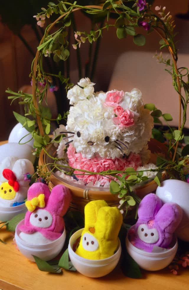 Hello Kitty floral arrangement in a basket with small colorful plush bunnies.
