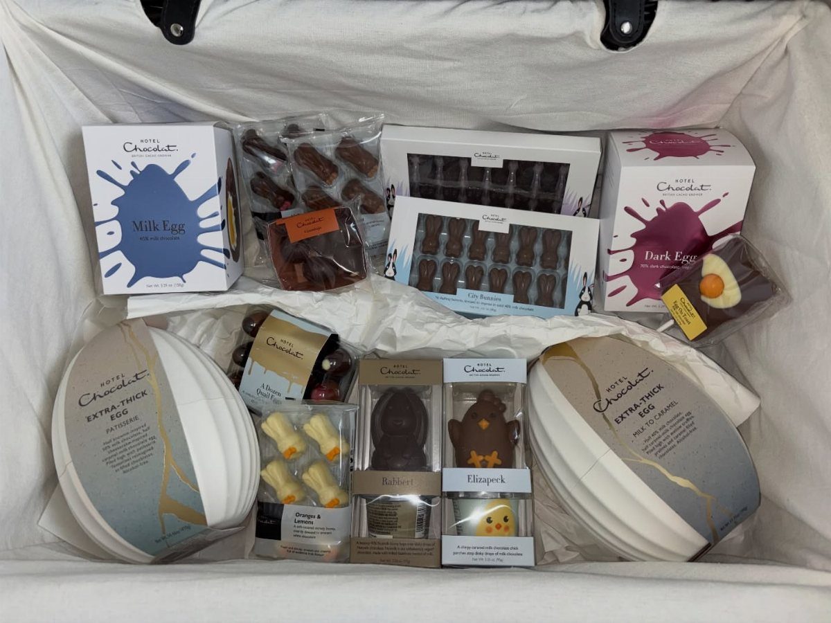 Assorted Hotel Chocolat Easter eggs and pralines arranged in a white gift basket.