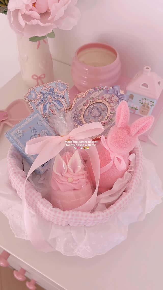 Pink Easter basket filled with a bunny plush, candle, and decorative cards.
