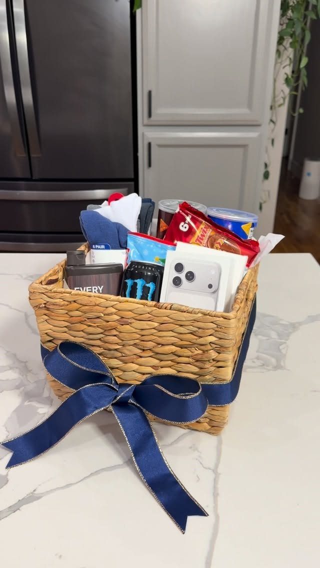 Woven wicker basket with navy ribbon filled with snacks and grooming products