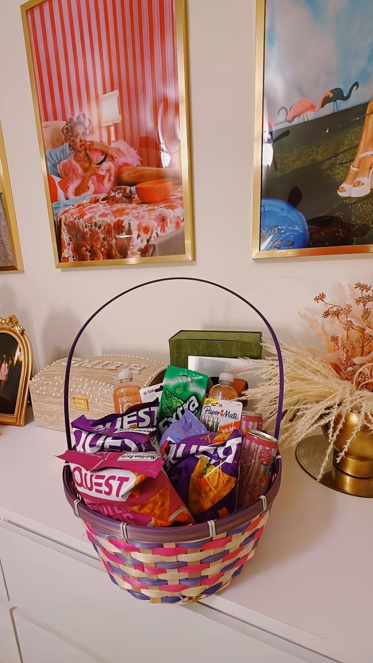 Colorful woven basket filled with protein snacks and treats on a white dresser.