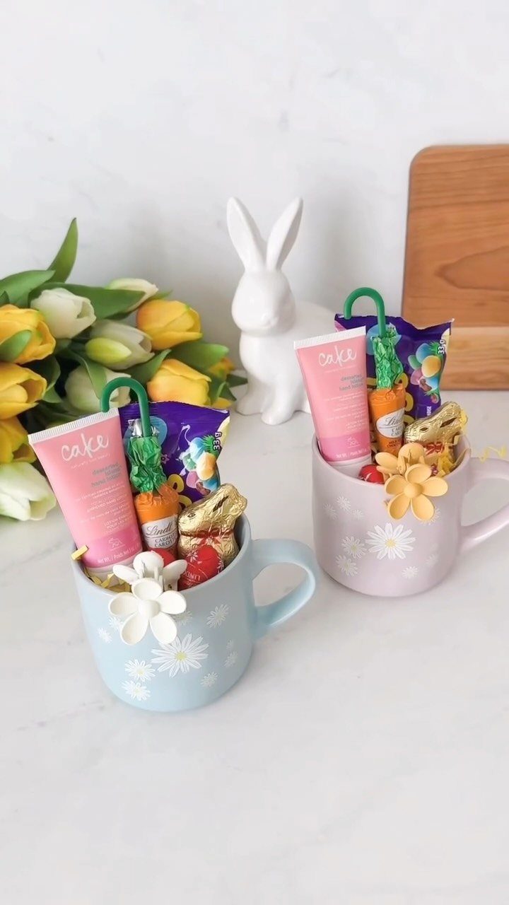 Two pastel mugs filled with Easter treats next to a white bunny figurine.