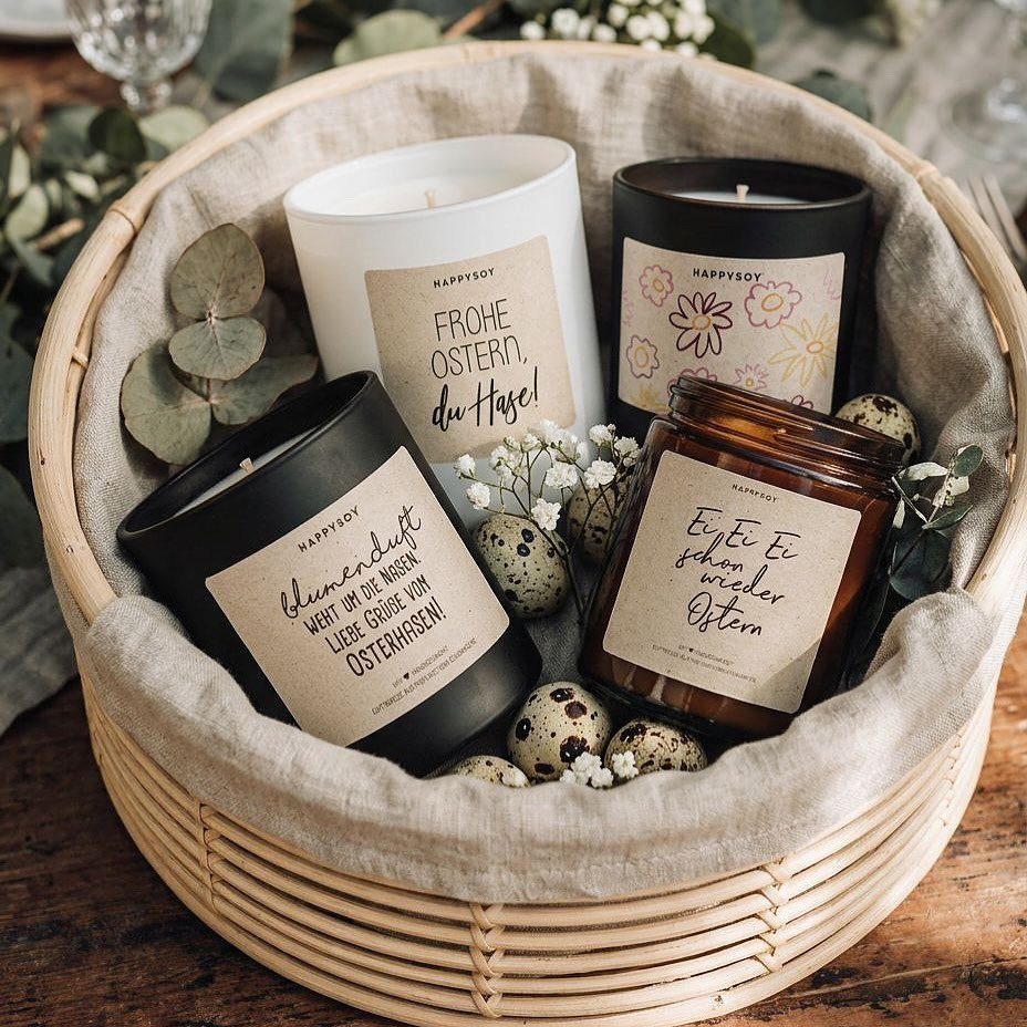 Four scented candles with Easter labels in a wicker basket with quail eggs.
