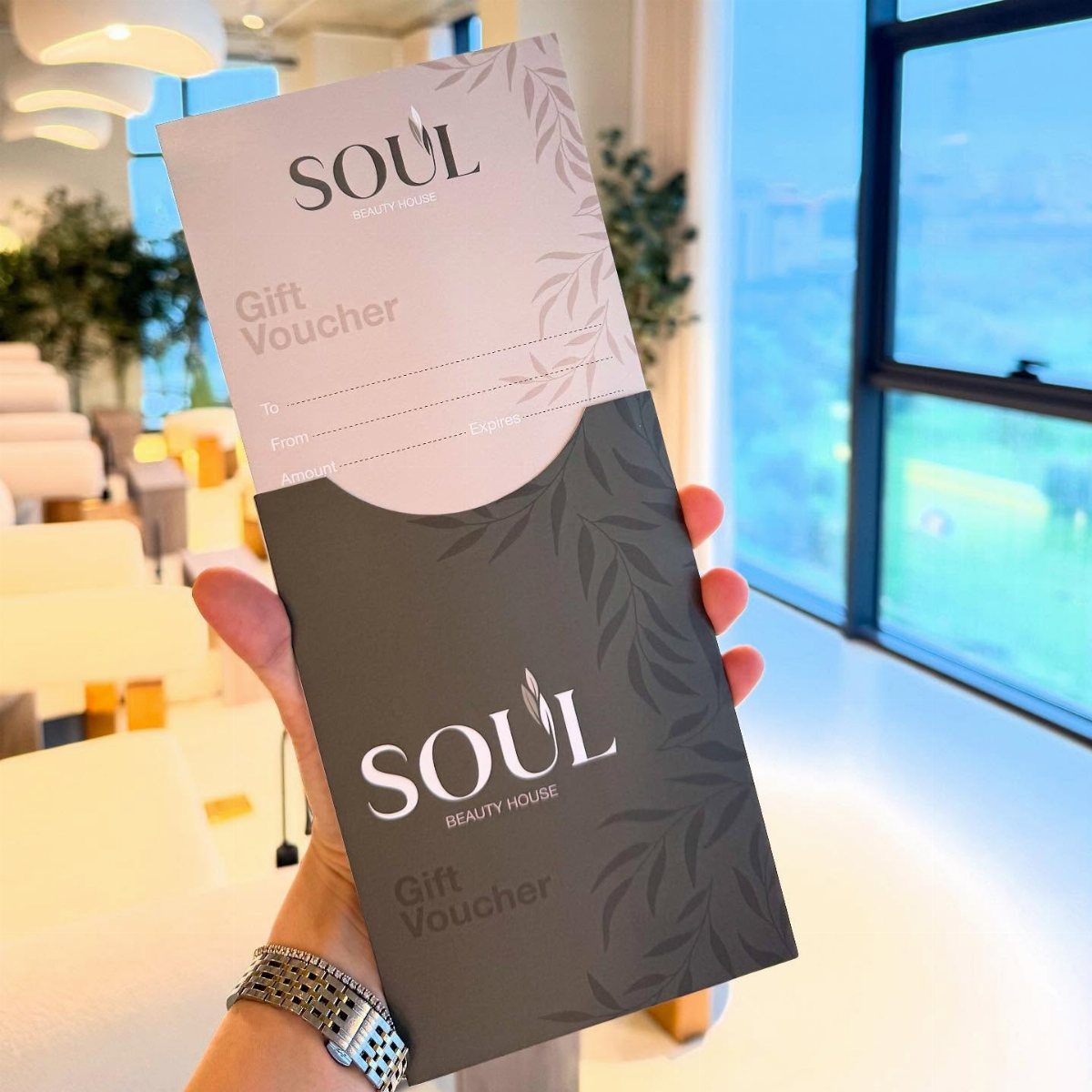 Gift voucher from Soul Beauty House held in a hand inside a salon.