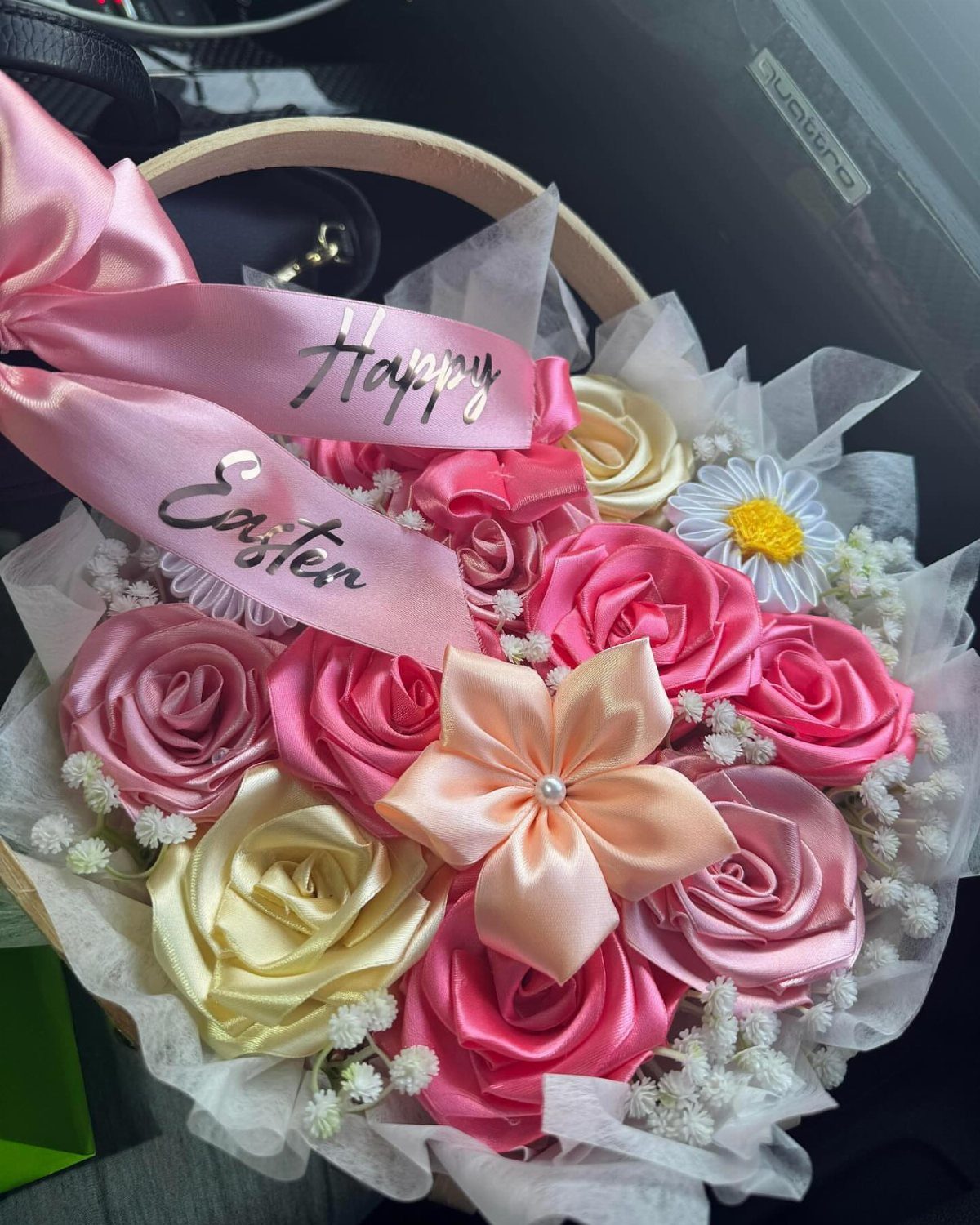 Satin ribbon roses in pink and cream inside an Easter gift basket.