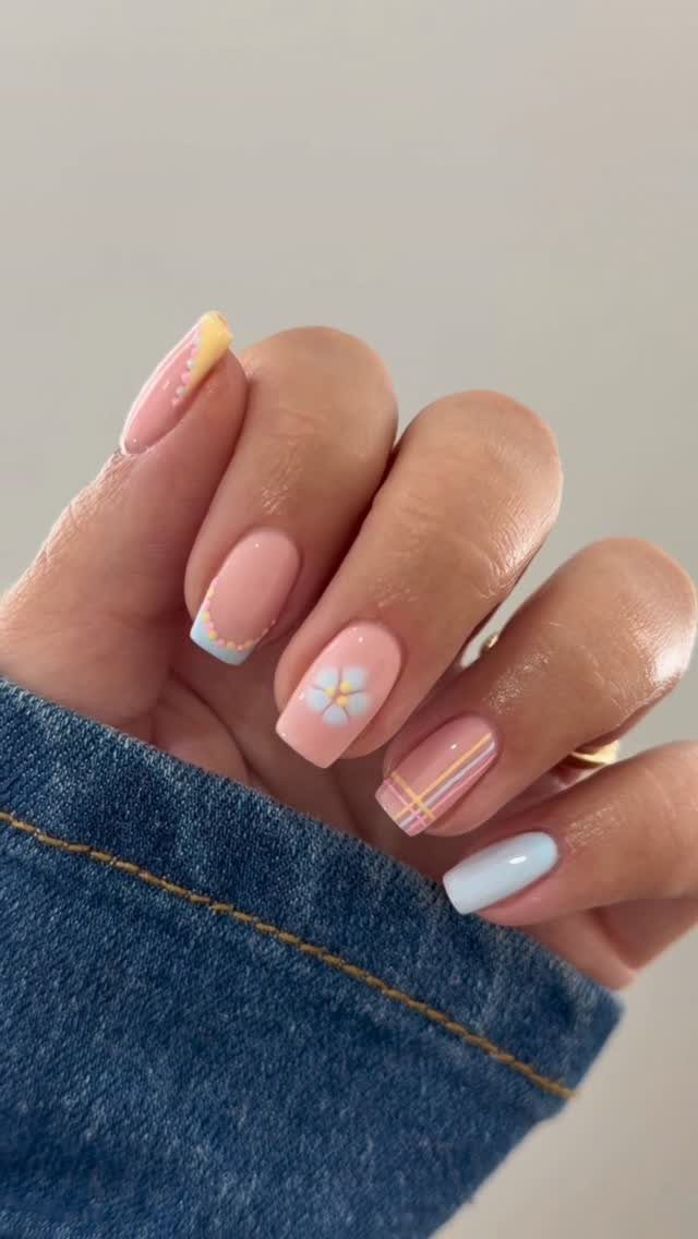 Manicured nails with a mix of floral, gingham, and pastel French tip designs.
