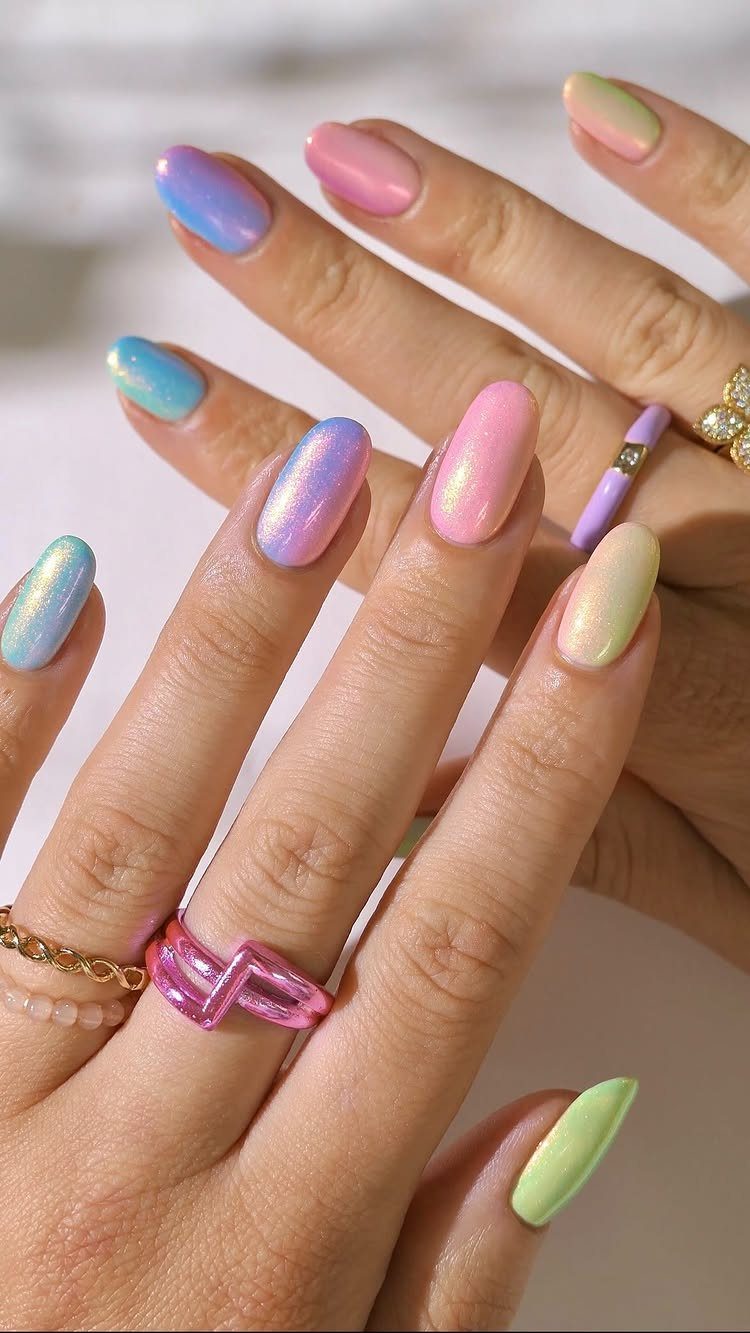 Pastel rainbow nails in shimmering pink, purple, blue, yellow, and green hues.