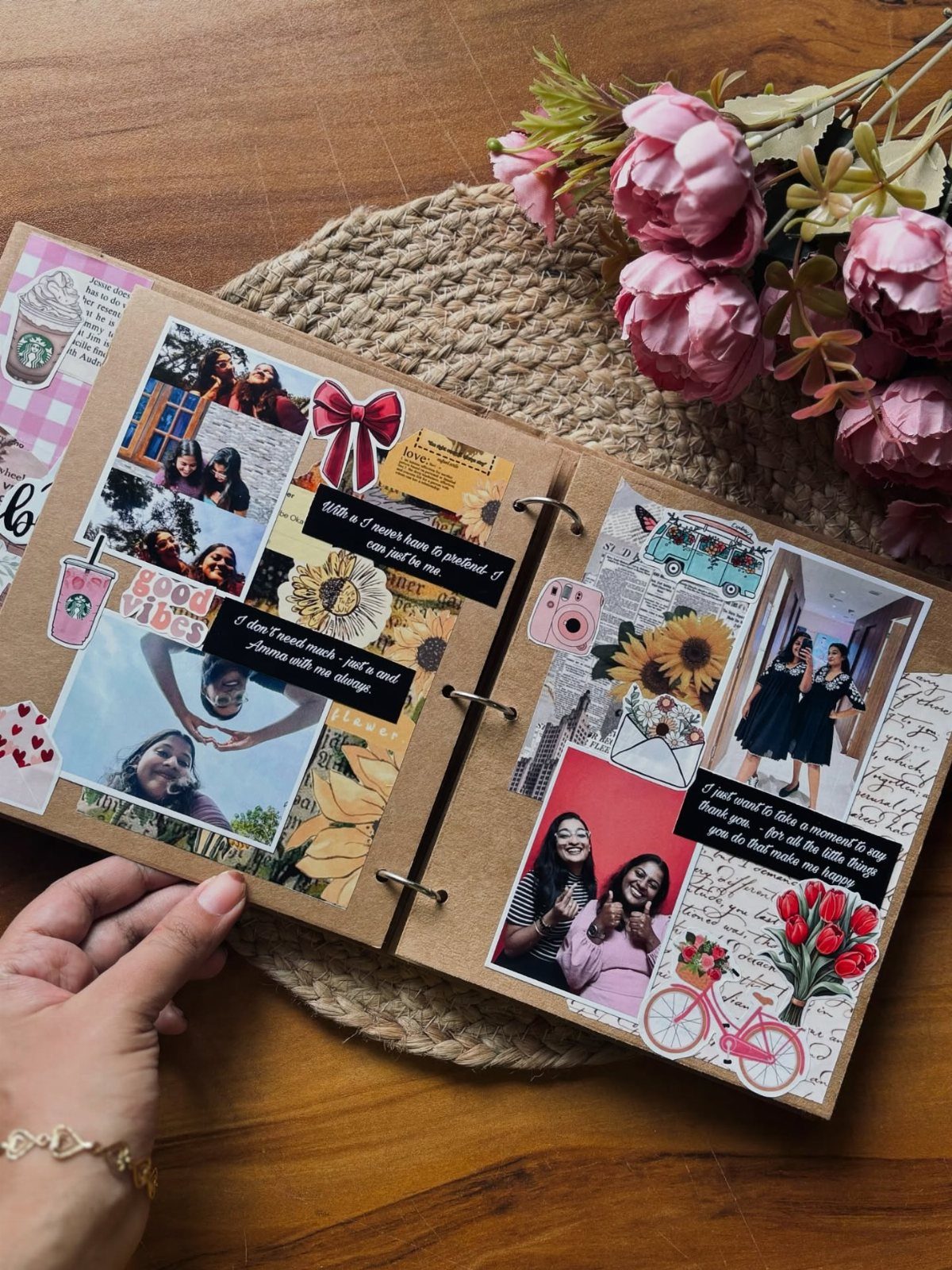 Open scrapbook with photos, stickers, and notes resting on a wooden table.