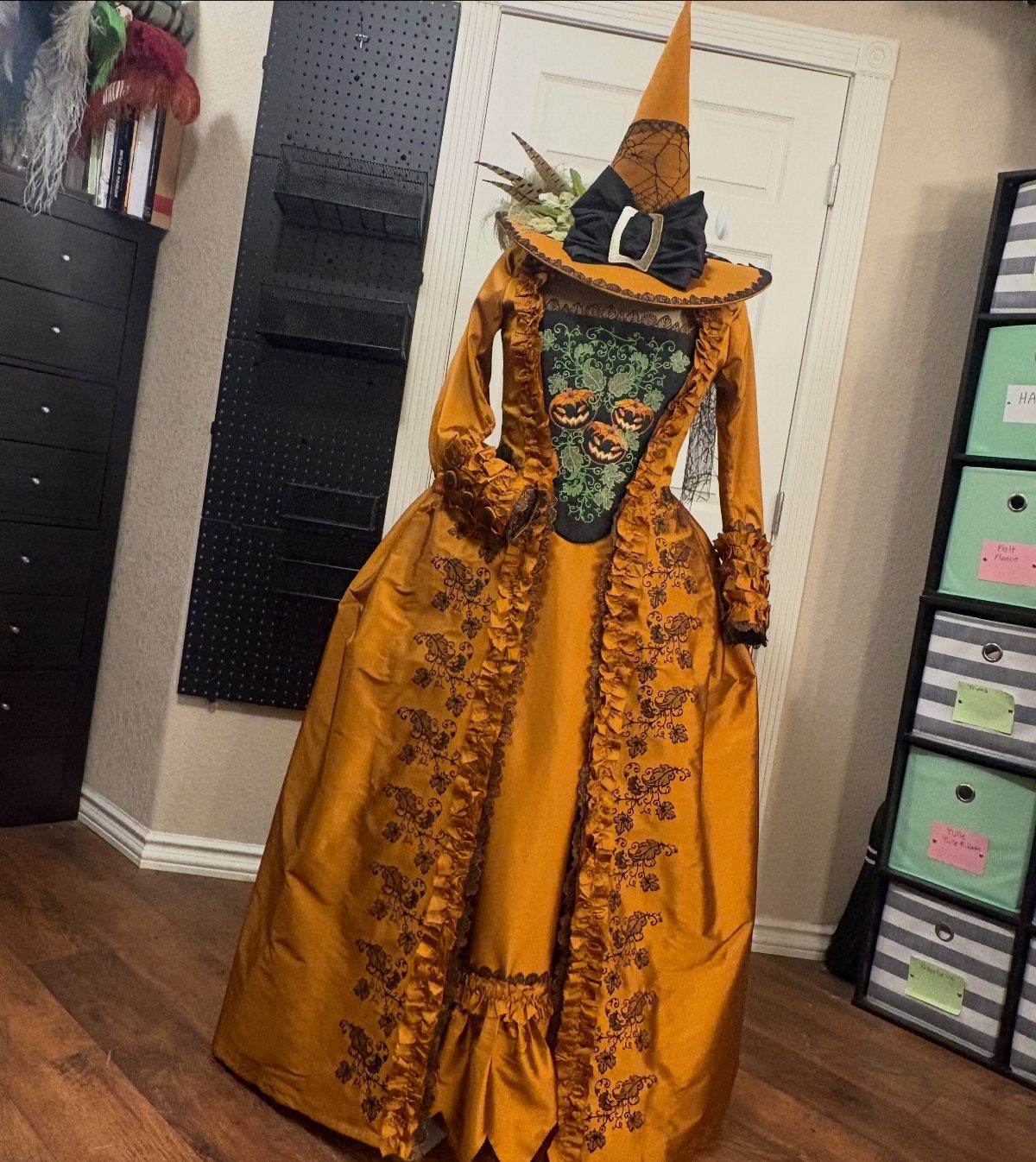 Orange witch gown with pointed hat and pumpkin bodice on a mannequin