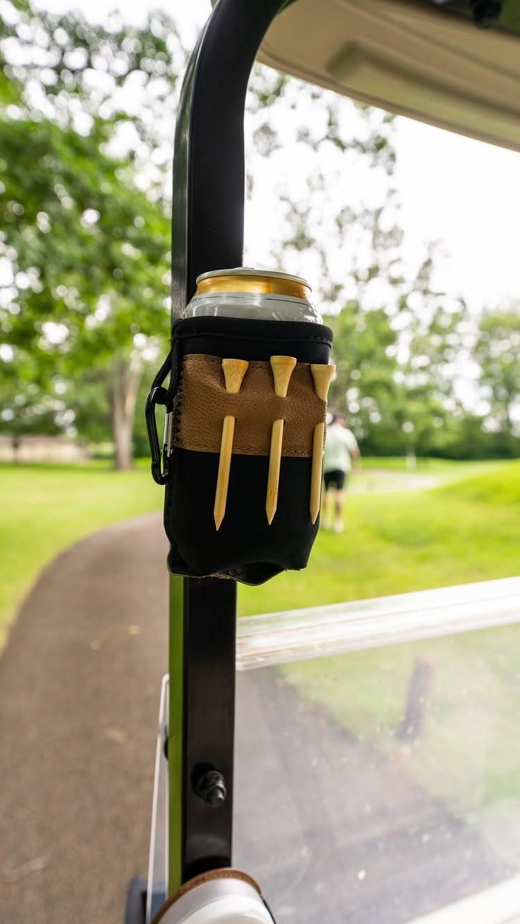 Handmade gauntlet-style beverage cozy holding a can on a golf cart frame