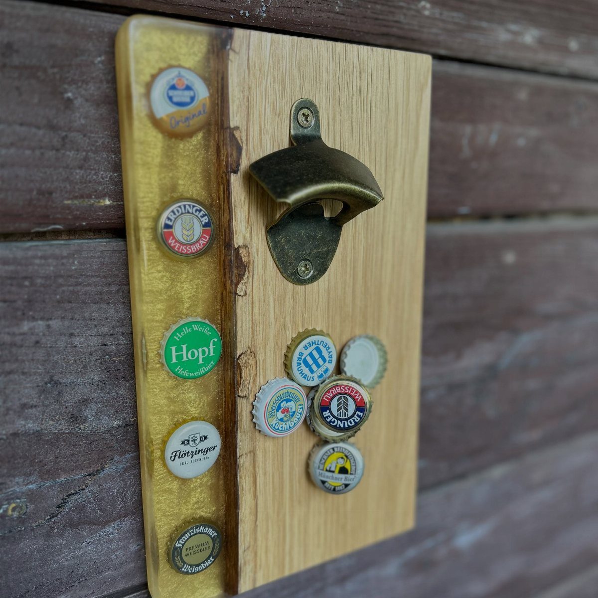 Wall-mounted wooden bottle opener with magnetic strip holding various colorful beer bottle caps.