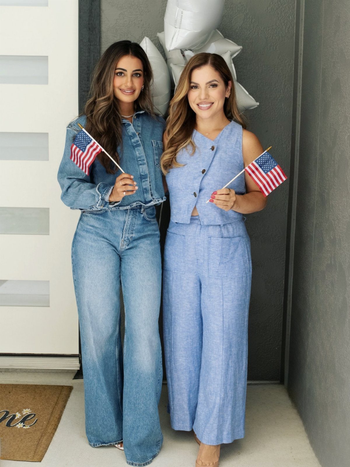 Two women wearing matching denim sets and holding small American flags.