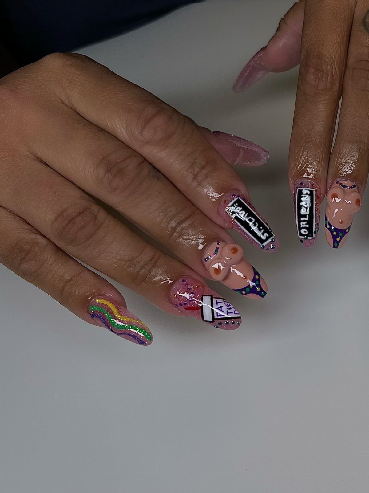 Long coffin nails with purple, green, and gold graffiti text and 3D accents.