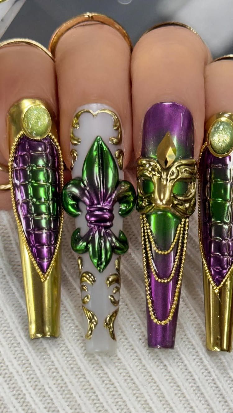 Stiletto nails with a 3D fleur-de-lis, gold mask, and purple and green colors.