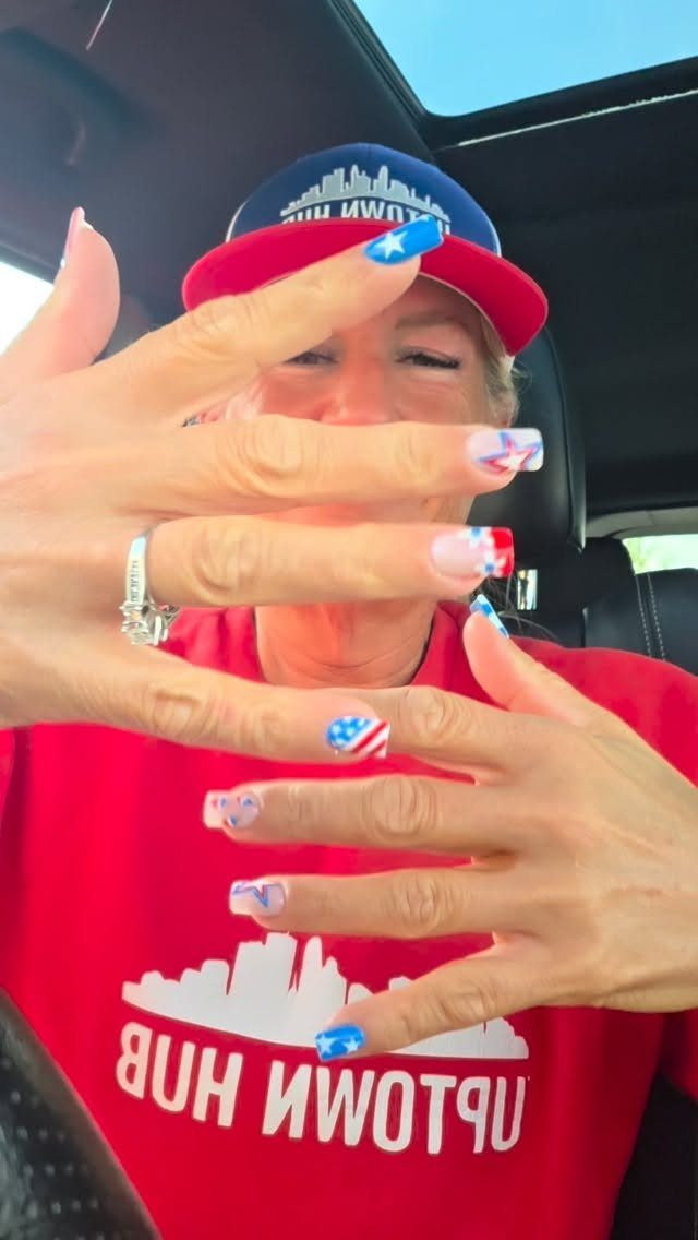 Short fingernails painted with red, white, and blue American flag nail art.