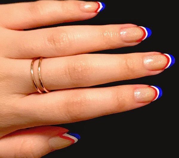 Short nails with gold glitter and red, white, and blue French tips.