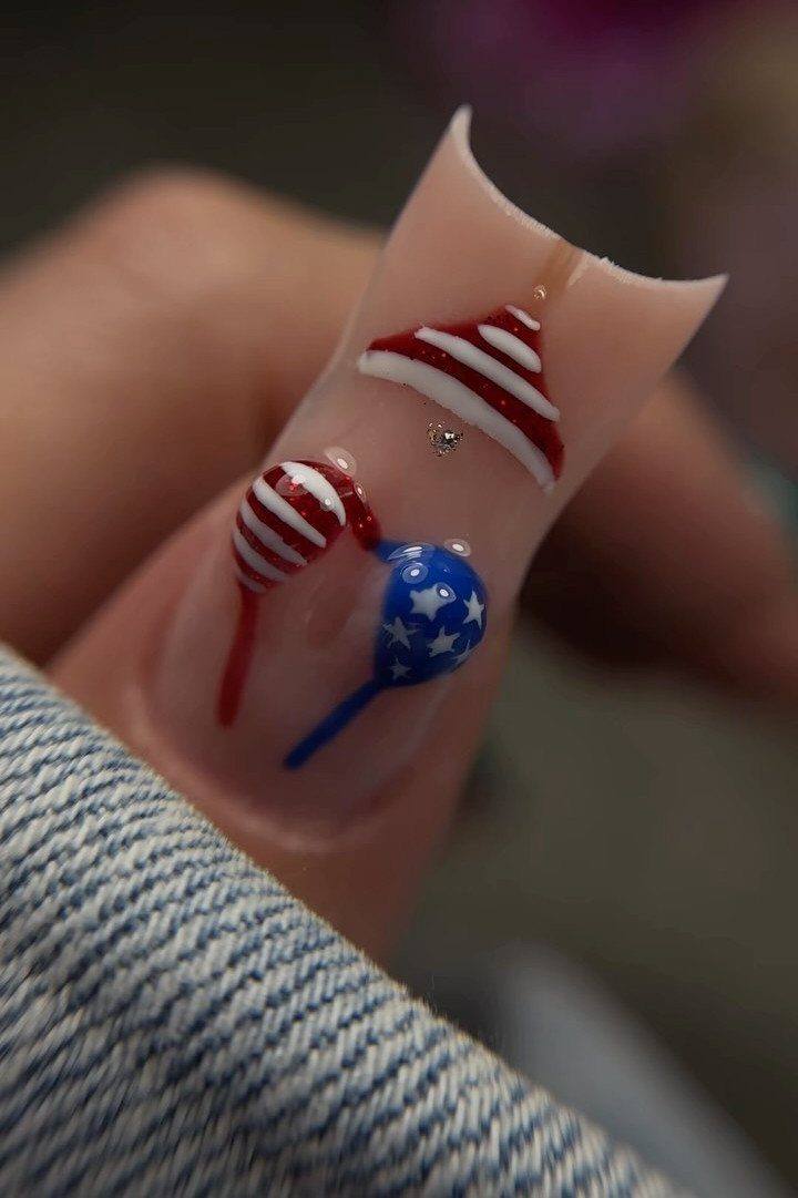 Long pointed nail with red, white, and blue 4th of July balloon art.