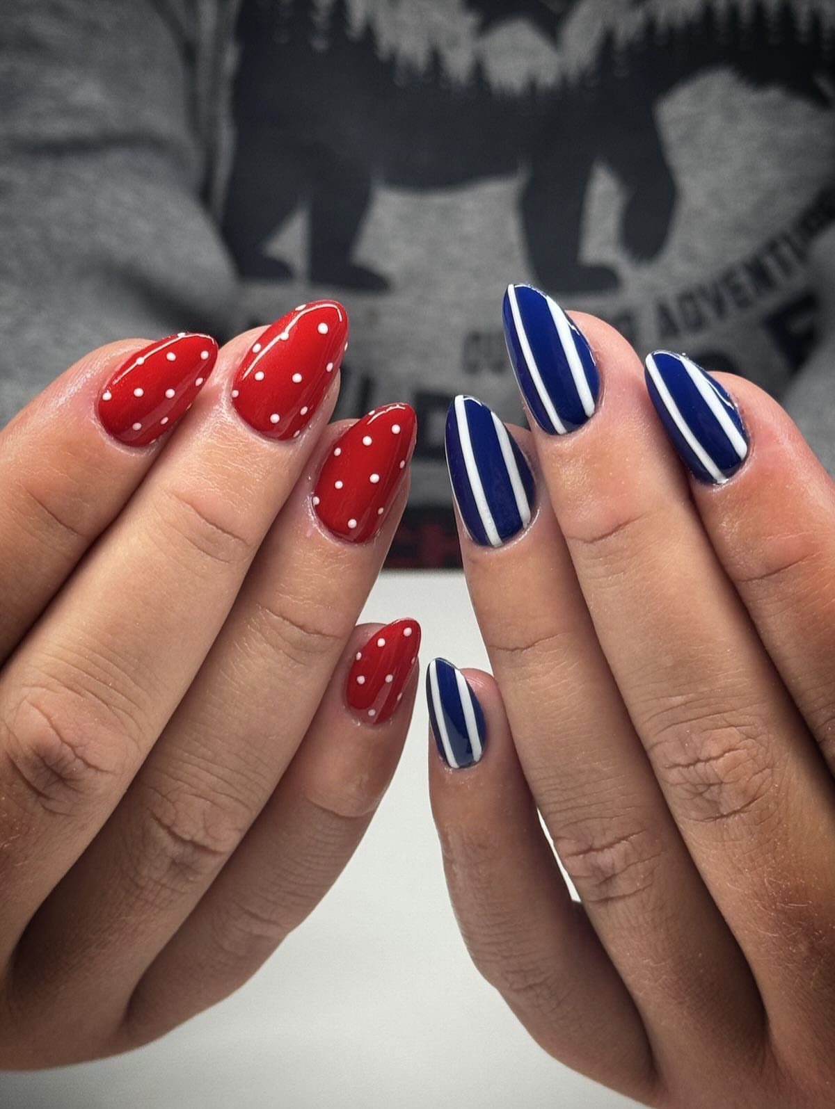 Red nails with white dots and blue nails with white stripes.