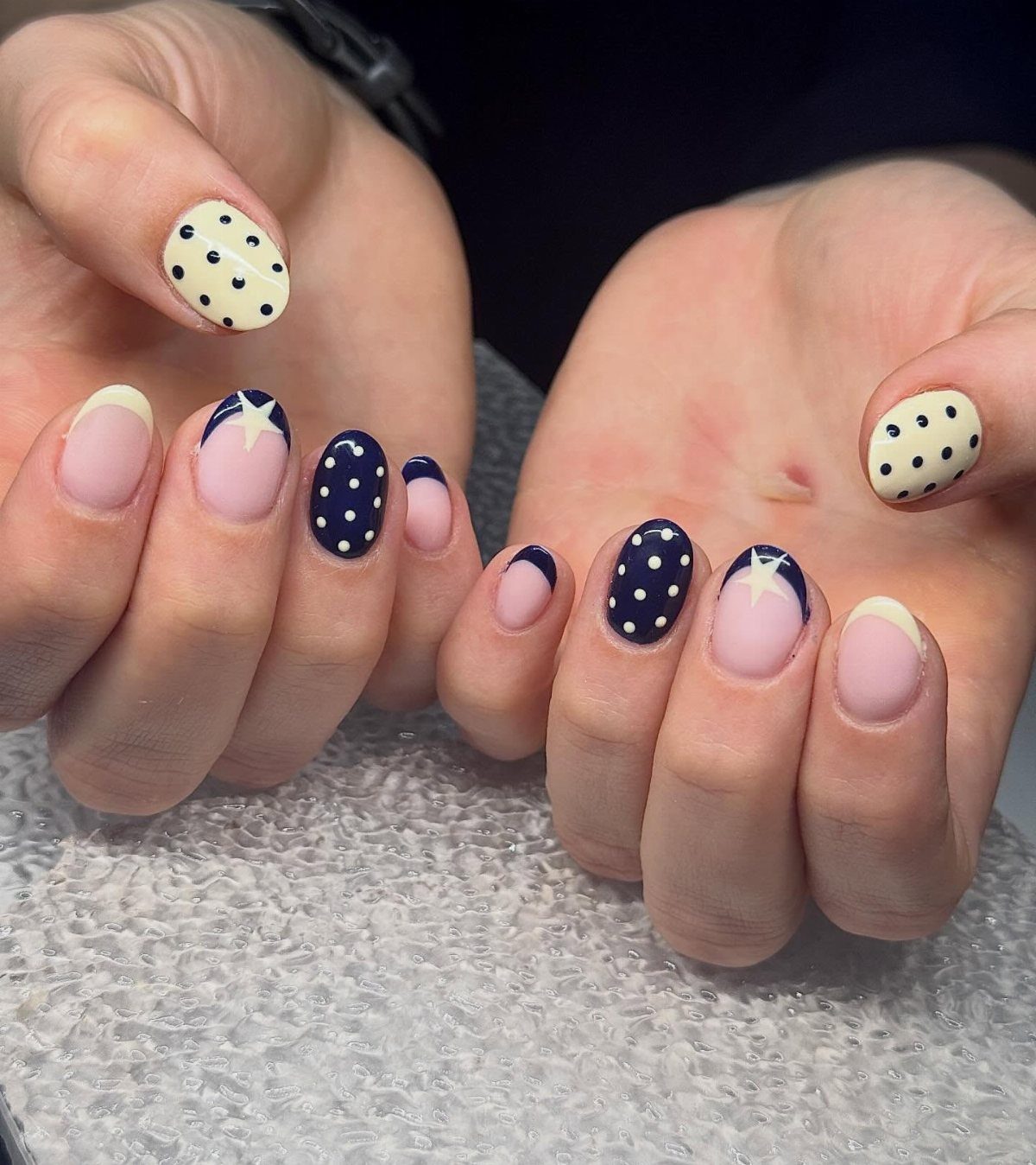 Manicured nails with red, white, and blue patriotic patterns including stars and polka dots.