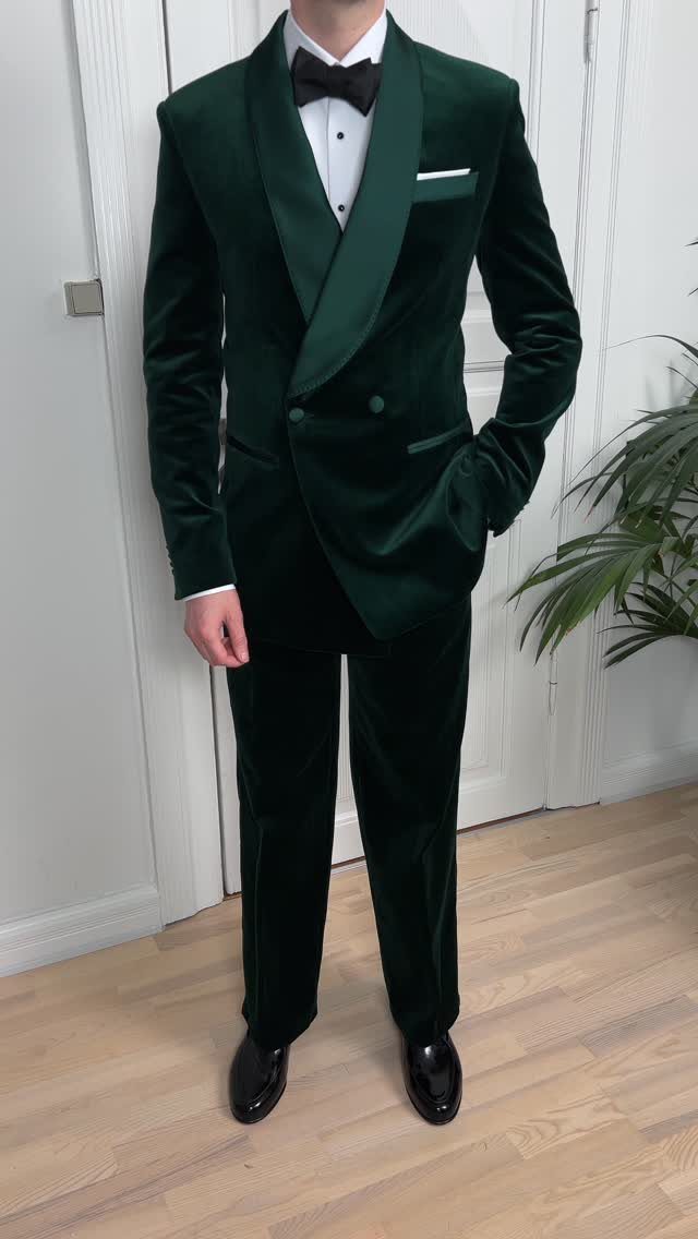 Man wearing a dark green velvet tuxedo with a black bow tie.