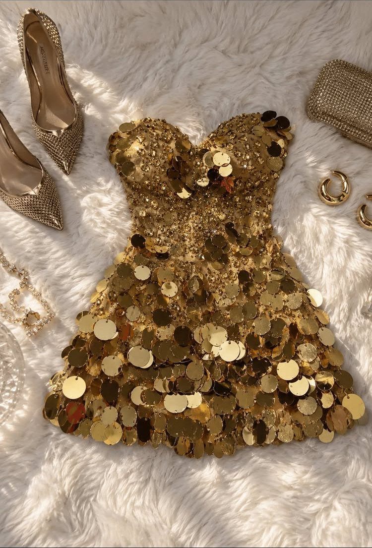 Gold sequin mini dress with matching glittery heels and accessories on white fur.