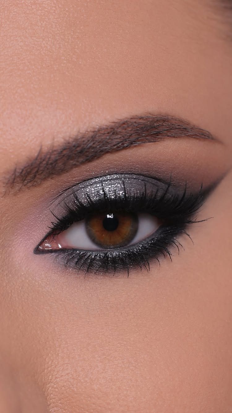 Eye with shimmering silver glitter eyeshadow and sharp black winged eyeliner