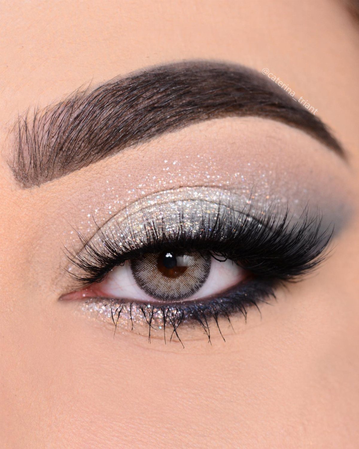 Eye makeup with silver glitter and a dark smoky outer corner and long lashes