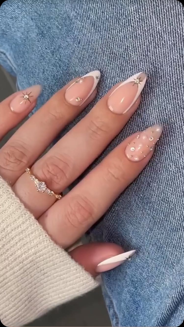 Almond nails with white French tips, small pearls, and star rhinestones on denim.