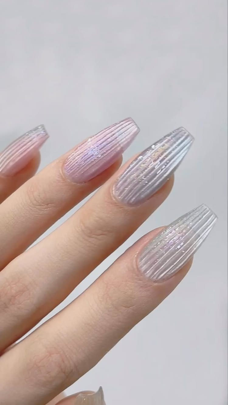 Iridescent purple and silver nails with raised vertical ridges on a hand.