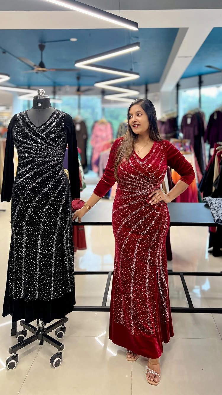 Woman wearing a red floor-length velvet dress with silver sparkles in a boutique.