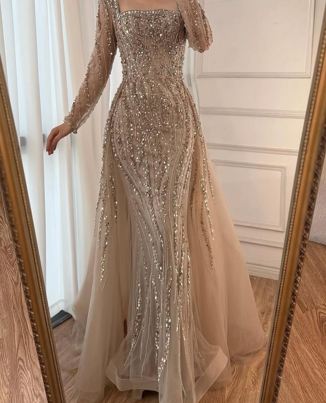 Champagne formal gown with gold sequins reflected in a gold-framed mirror