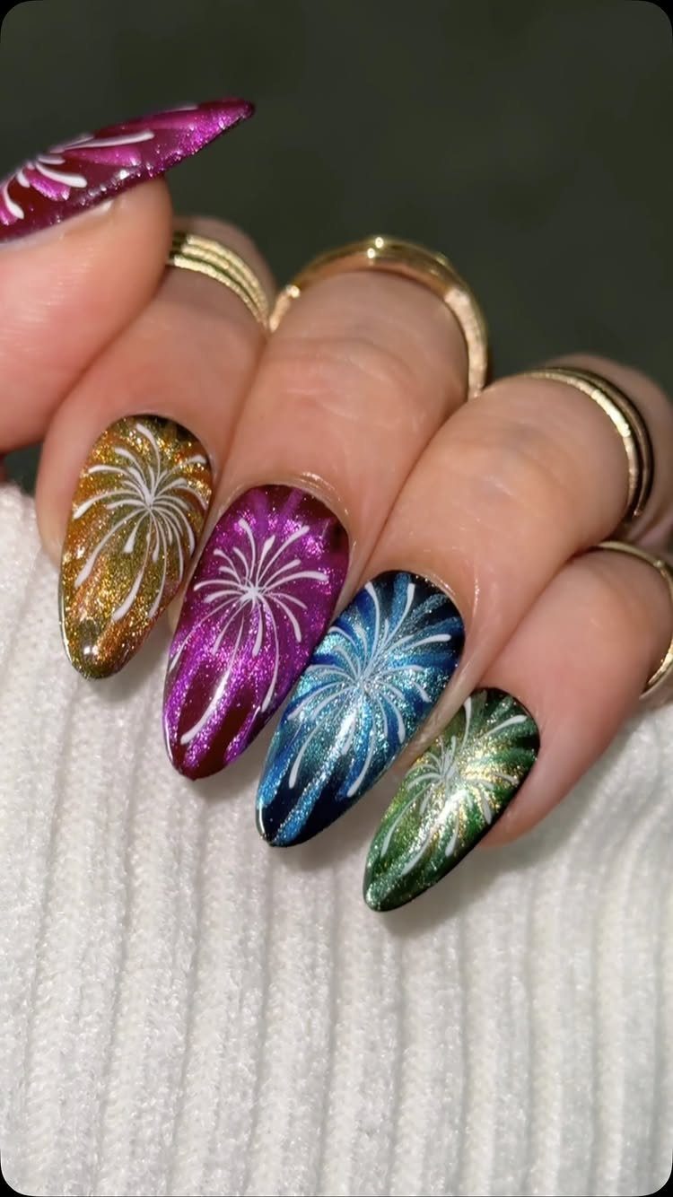 Almond-shaped nails with colorful glitter and white firework designs on each finger.