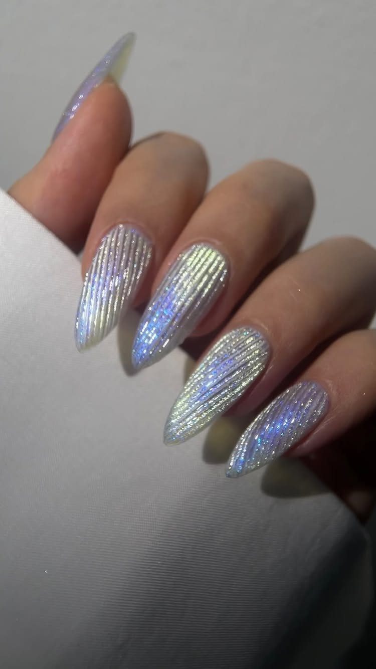 Holographic iridescent nails with raised vertical ridges on a hand.